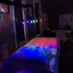 Image of therapy room with a bed with rainbow crystal lights above